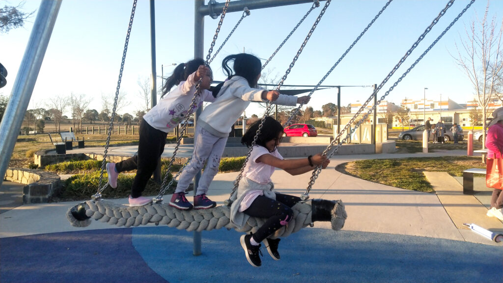 3 girls swinging together on Kaiser and Kuehne viking swing