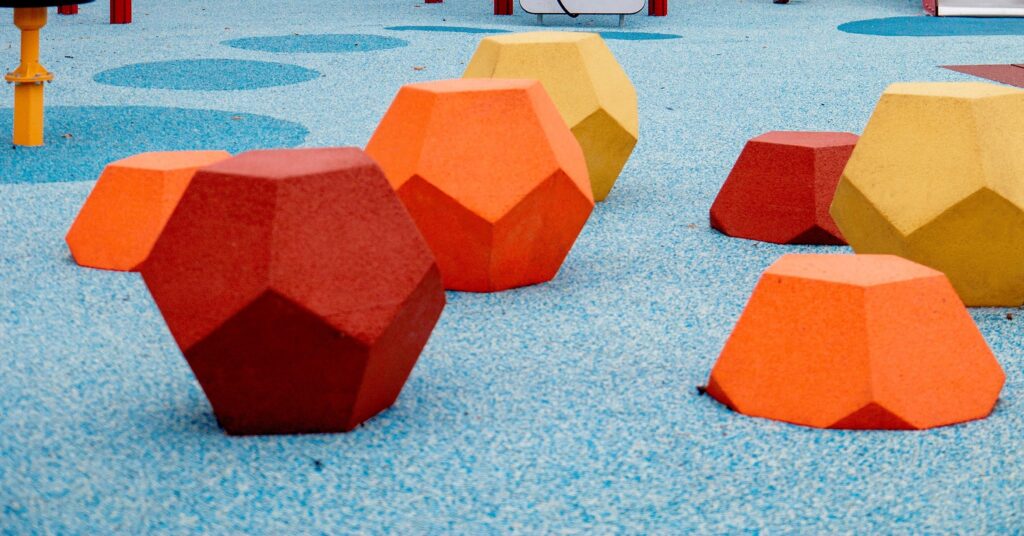 Red, yellow and orange EPDM diamonds on light blue EPDM surfacing
