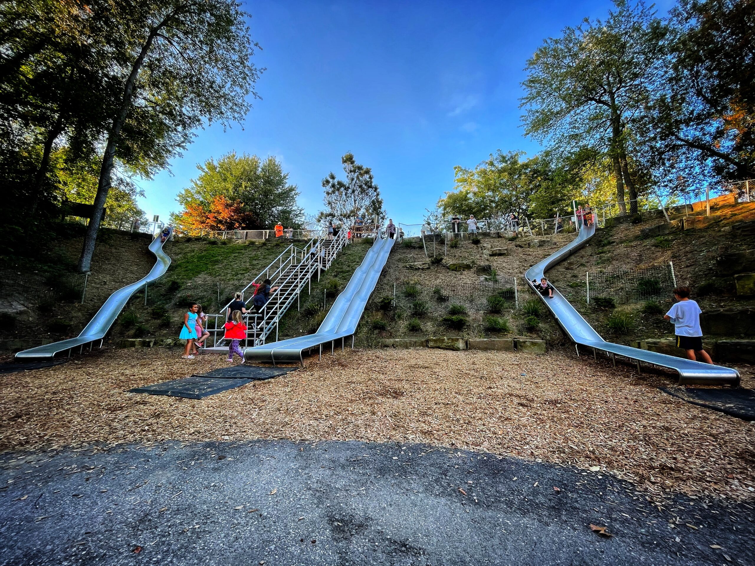 Children playing on 3 hill slides