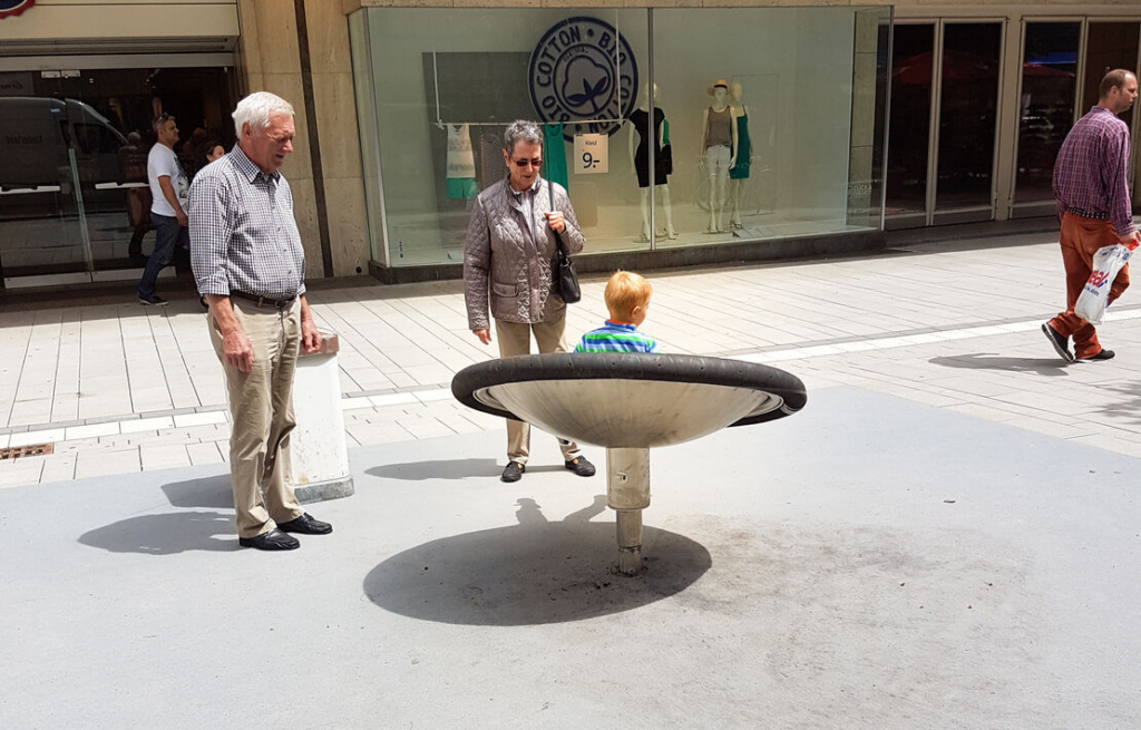 Grandparents watching child spin and play in the Kalotta Turner